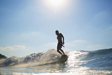 Male surfer riding sunny ocean wave 01