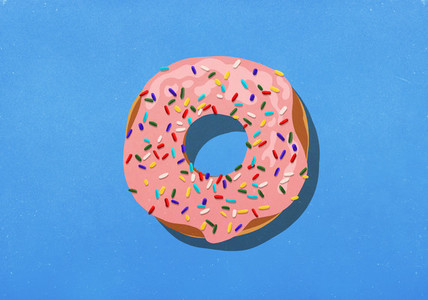 Pink donut with sprinkles on blue background