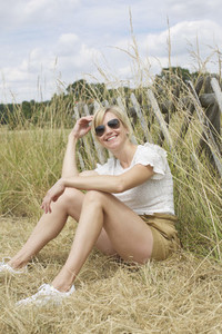 Portrait confident  carefree woman sitting in tall grass
