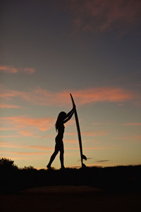 Silhouette female surfer with surfboard on beach at dusk 02