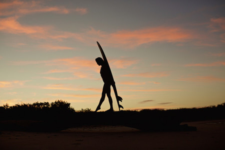 Silhouette female surfer with surfboard on beach at dusk 03