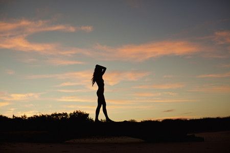 Silhouette woman on beach at dusk 02