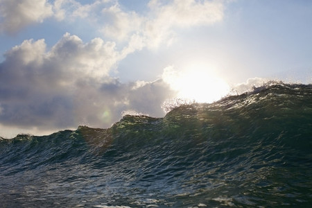 Sun shining over cresting ocean wave