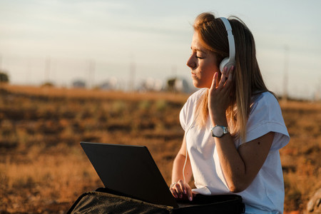 Young woman with her laptop listened external communications