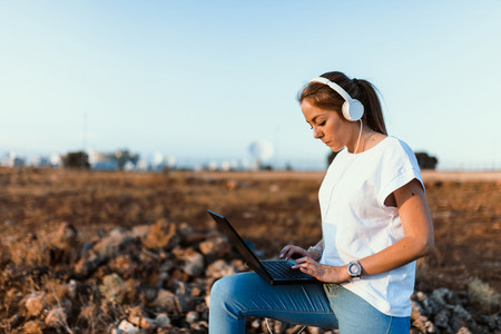 Young woman with her laptop communicates with antennas