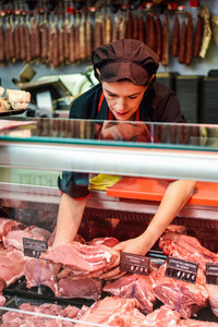 Butchers hands holding meat piece in shop