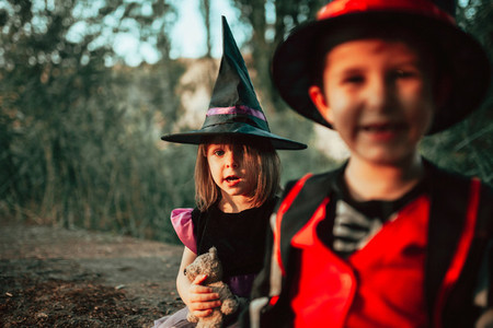Two children disguised for Halloween in the woods
