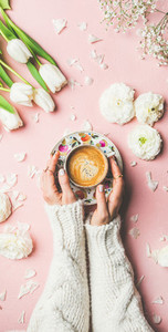 Spring layout with Coffee in female hands and white flowers