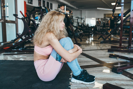 Girl sits on the floor in the gym