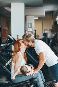 Young family with little boy in the gym