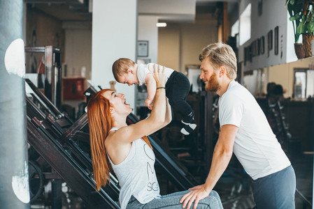 Young family with little boy in the gym