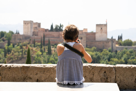 Little girl making photo with DSLR camera to the Alhambra
