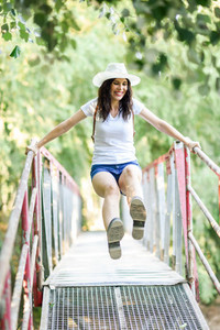 Woman with backpack standing on rural bridge