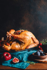 Roasted whole turkey on a table with apple  pumpkin and figs for family Thanksgiving Holiday