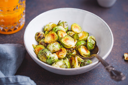 Roasted brussel sprouts in a ceramic bowl on a table The concept of healthy vegetarian eating