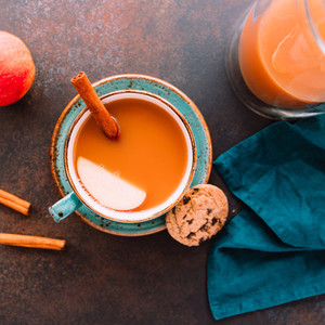 Wintertime chai spiced apple cider with assam tea  cinnamon  ginger  cardamom and almond milk  Christmas or Thanksgiving cozy flat lay