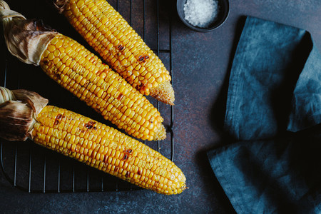 Roasted or grill corn cob with olive oil and salt on a rack Tasty simple recipe top view