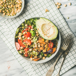 Vegan bowl with avocado grains beans and vegetablesmarble background