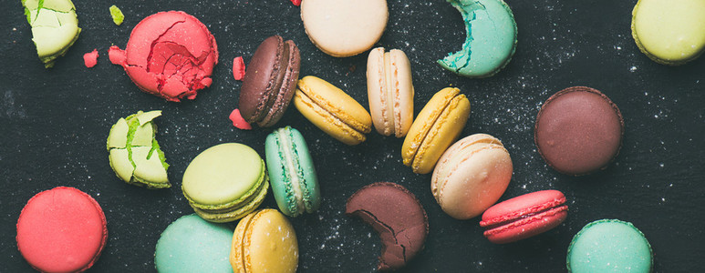 Flat lay of sweet colorful French macaroon cookies variety  wide composition
