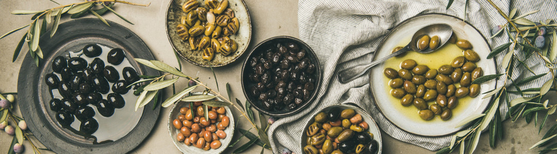 Mediterranean pickled olives and olive tree branches  wide composition