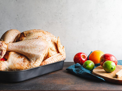 Raw whole turkey with fruits for stuffing on a kitchen table  preparing Thanksgiving or Christmas recipe