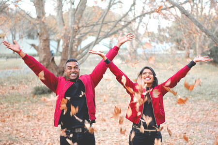 Couple throwing autumn leaves