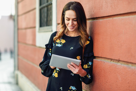 Smiling young woman using digital tablet outdoors