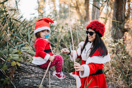 Mom and daughter disguised to christmas on the forest