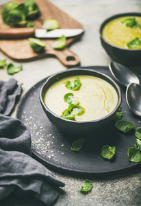 Brussels sprouts vegetable cream soup in black bowls  selective focus
