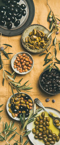 Mediterranean pickled olives and olive tree branches yellow background