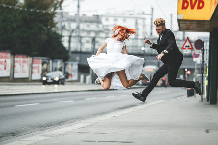 Wedding couple jumping in the city