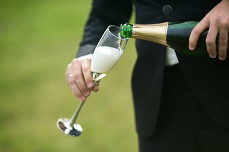 Groom pours a glass of champagne