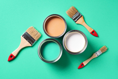 Paint brushes and open paint cans with on trendy green background  Top view  copy space  Appartment renovation  repair  building and home design concept
