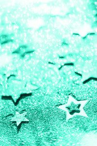 Christmas celebration  Abstract background for new year party  Patter of gold stars with lights  bokeh  Trendy green and turquoise color  Glitter stars in mint color
