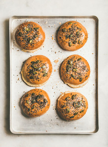Freshly baked buns with seeds for cooking burgers top view