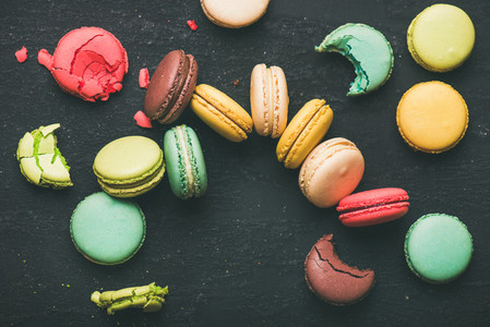 Flat lay of colorful French macaroons over black background