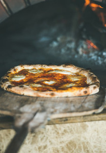 Freshly baked pizza with cheese in pizza wood oven