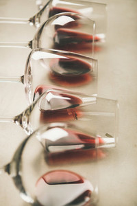 Red wine in different glasses over grey background  selective focus