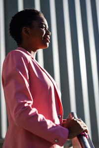 Smiling black businesswoman standing near business office building