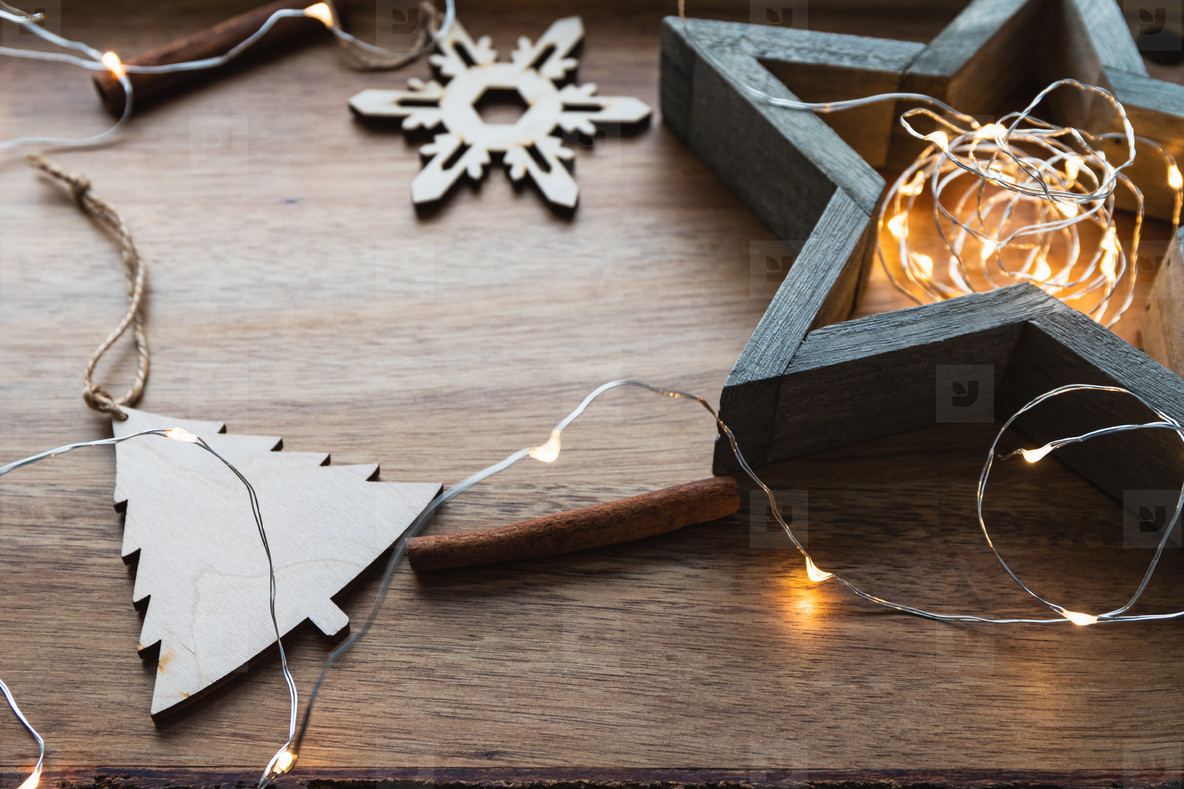 Festive Christmas or New Year flat lay with wooden fir toys and festoon on a wooden background