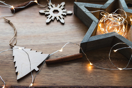 Festive Christmas or New Year flat lay with wooden fir toys and festoon on a wooden background