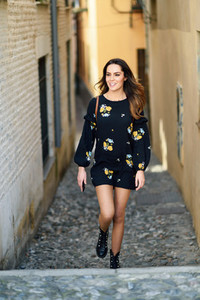Young woman walking in urban background Female in casual clothes with care hair