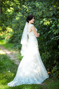 Beautiful bride in a gorgeous dress posing in a pine forest