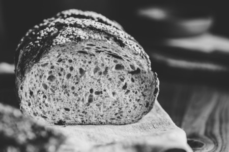 Whole grain loaf bread with chia seeds on a cutting board  Healthy eating concept  Black and white photography