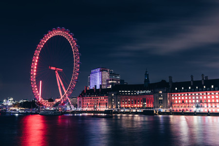 London eye wheel on modern city skyline at night