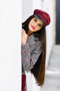 Beautiful girl with very long hair wearing winter coat and cap outdoors