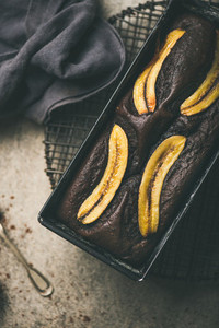Chocolate banana cake with cinnamon in baking tin vertical composition