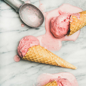 Homemade strawberry yogurt ice cream with mint in cones