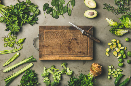 Healthy vegan ingredients and wooden board and knife in center