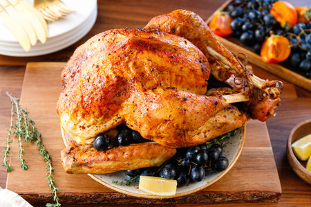 Roasted whole turkey on a table with fruits for family Christmas or Thanksgiving Holiday